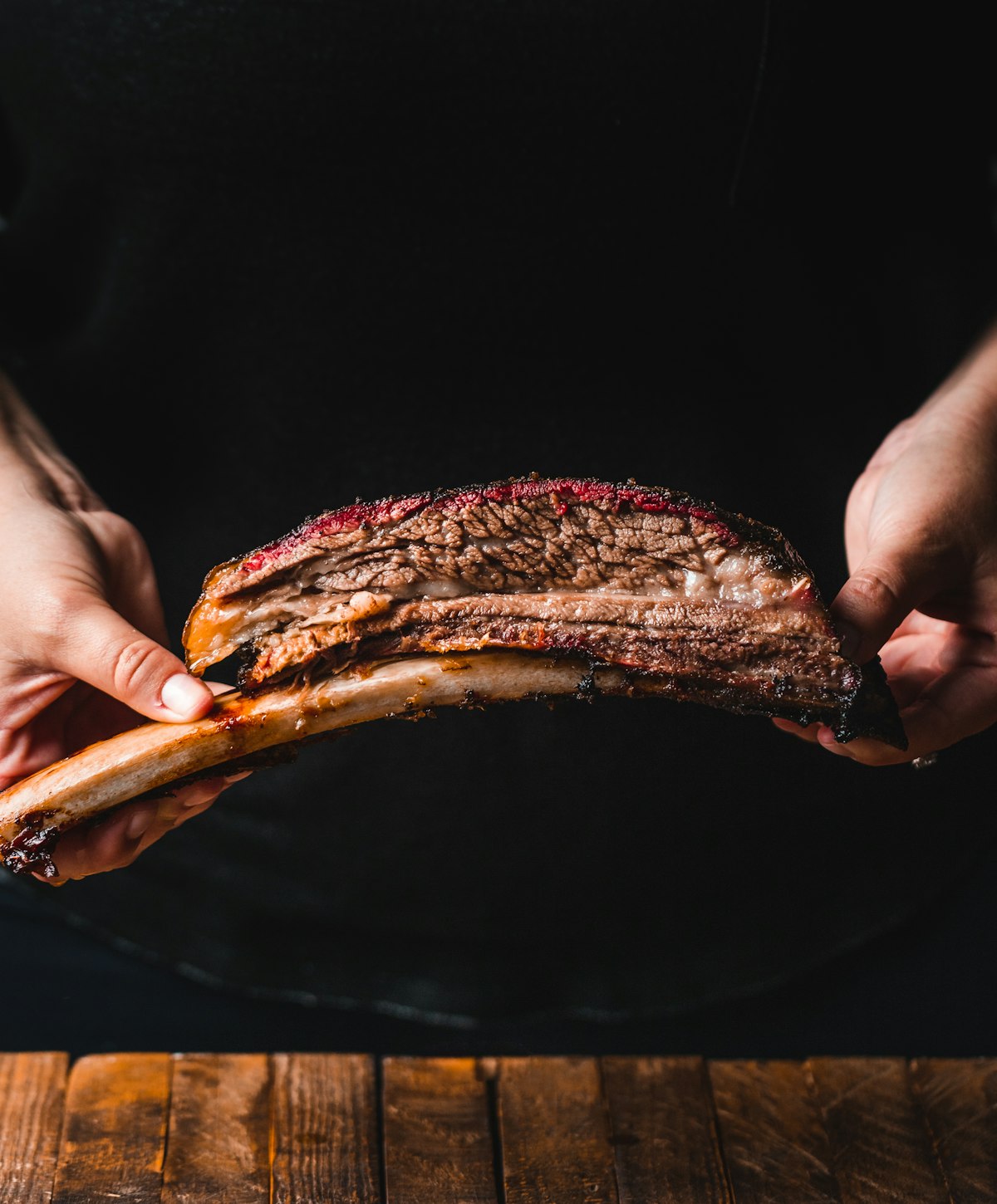 Short ribs av storfe holdt i hendene